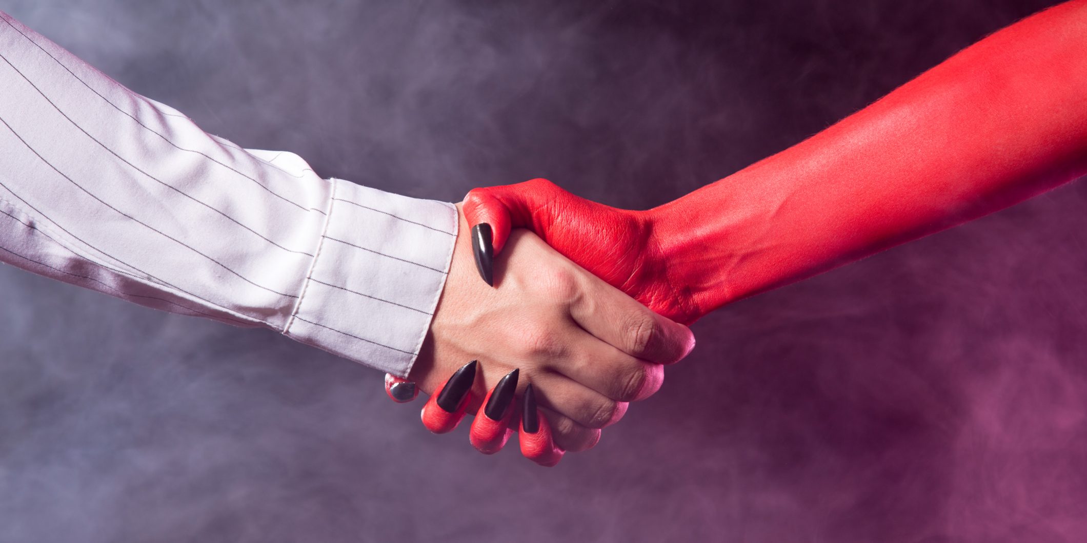 Businessman making a deal with devil