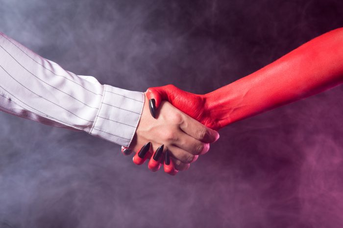 Businessman making a deal with devil